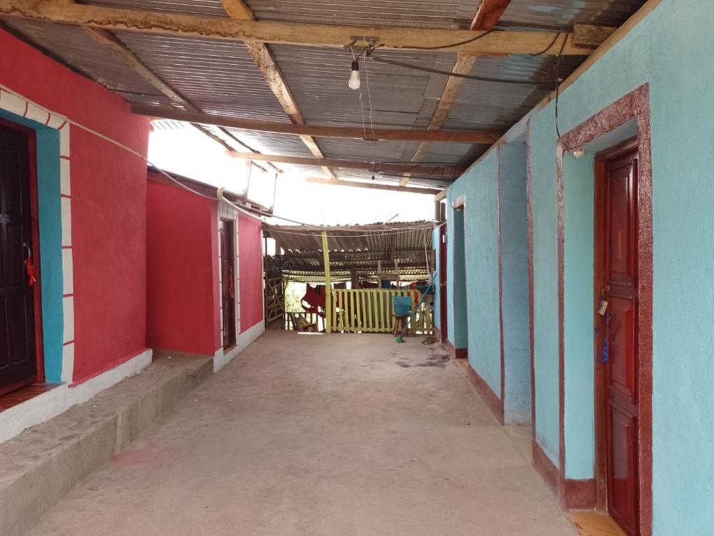 un couloir vide d'un bâtiment aux murs rouges et bleus dans l'établissement Casa Ricardo Sonis, à Somoto