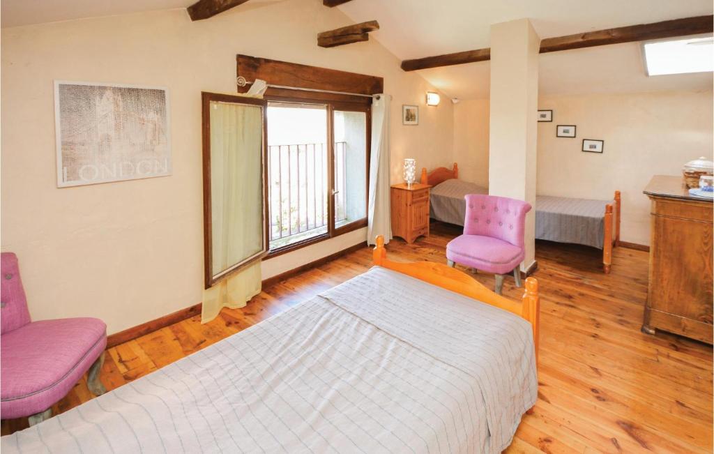a bedroom with a bed and two chairs at Amazing Home In Barjac With 3 Bedrooms, Wifi And Outdoor Swimming Pool in Barjac
