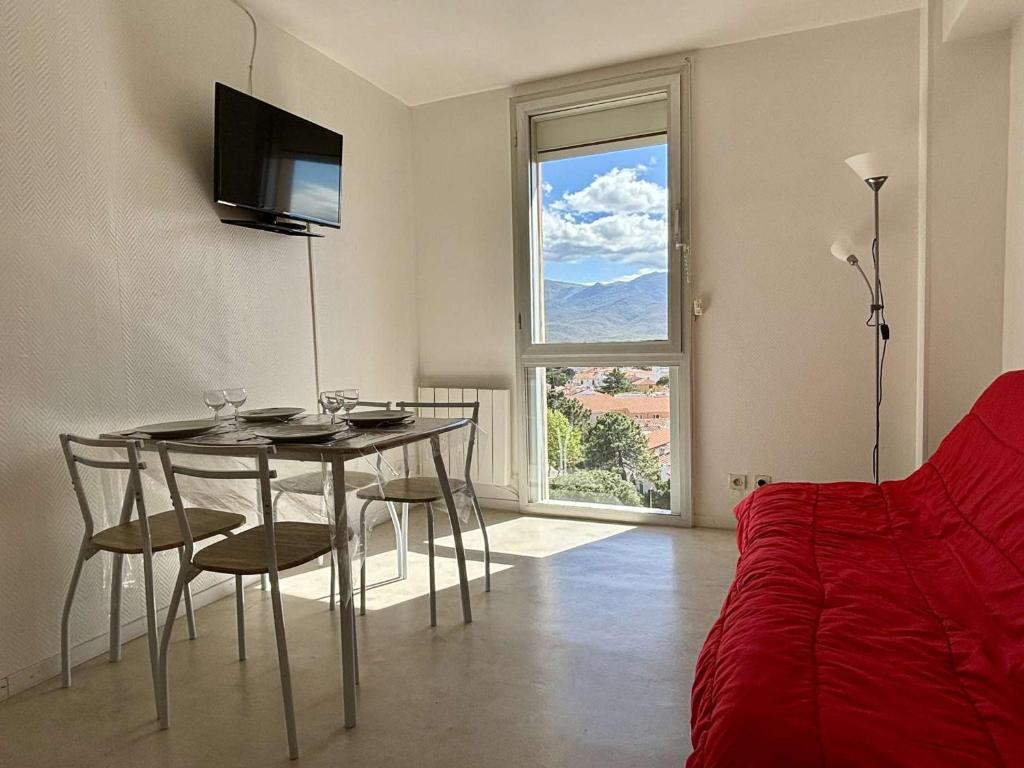 um quarto com uma mesa e cadeiras e uma janela em Appartement Argelès-sur-Mer, 2 pièces, 4 personnes - FR-1-225-814 em Argelès-sur-Mer