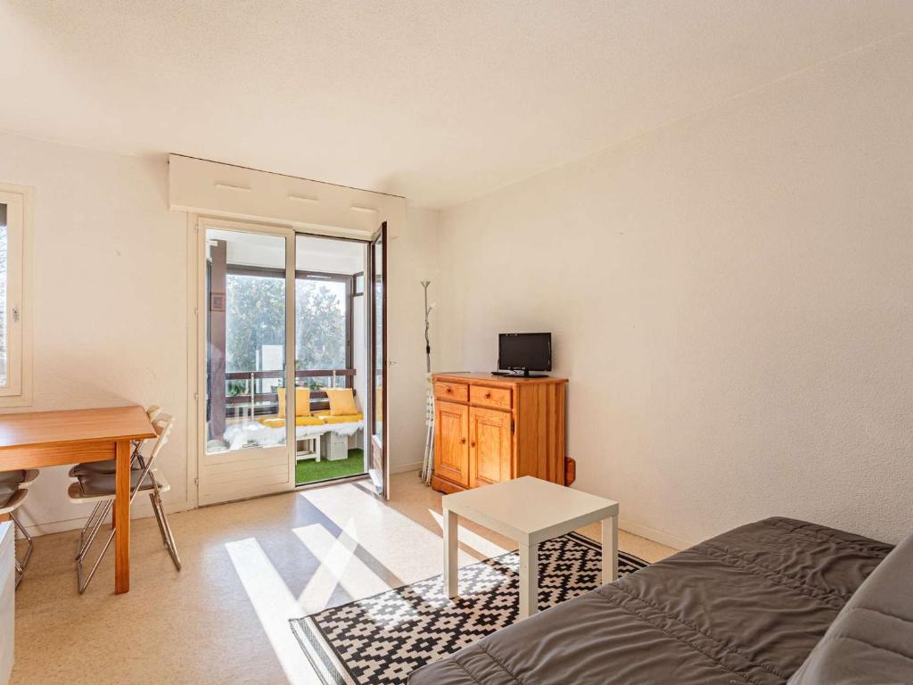 une chambre avec un lit, un bureau et une table dans l'établissement Appartement à Anglet : proche commerces, plages, et nature, avec parking et loggia - FR-1-3-606, à Anglet