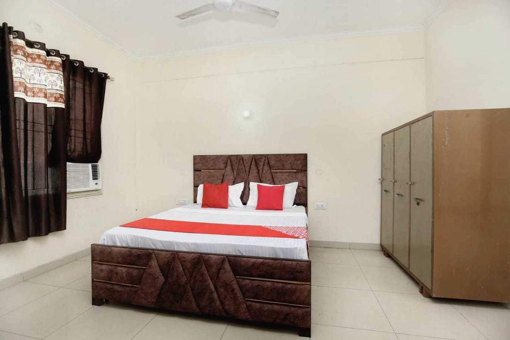 um quarto com uma cama grande e almofadas vermelhas em OYO Hotel Golden Crown em Sirhind