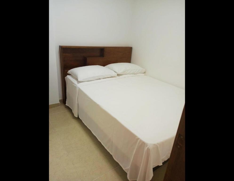 a bed with two pillows on it in a room at KOKOA GARDEN INN in San Vicente de Chucurí