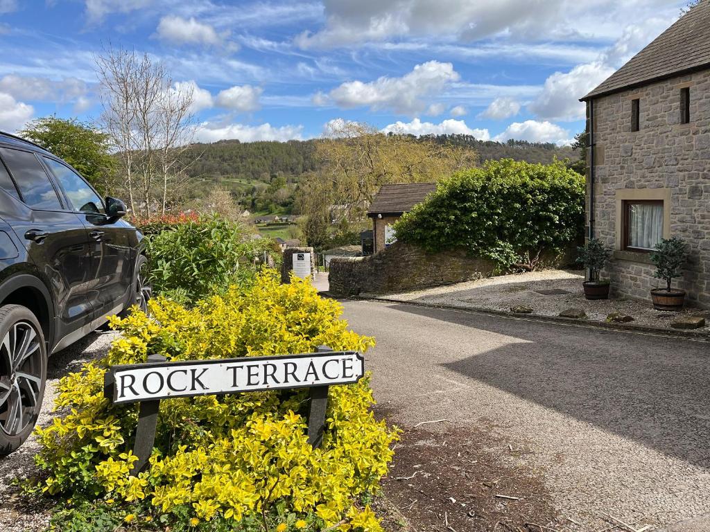 a rock terrace sign in front of yellow flowers at Rock Terrace View in Bakewell