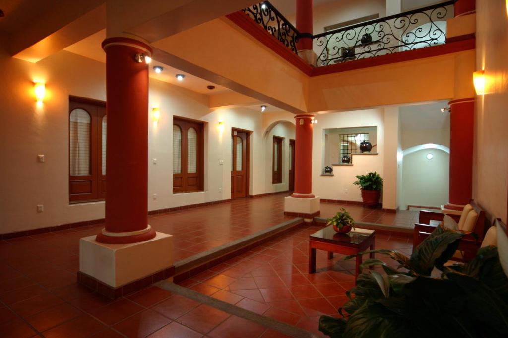 a large living room with columns and a table at Hotel Oaxaca Mágico in Oaxaca City