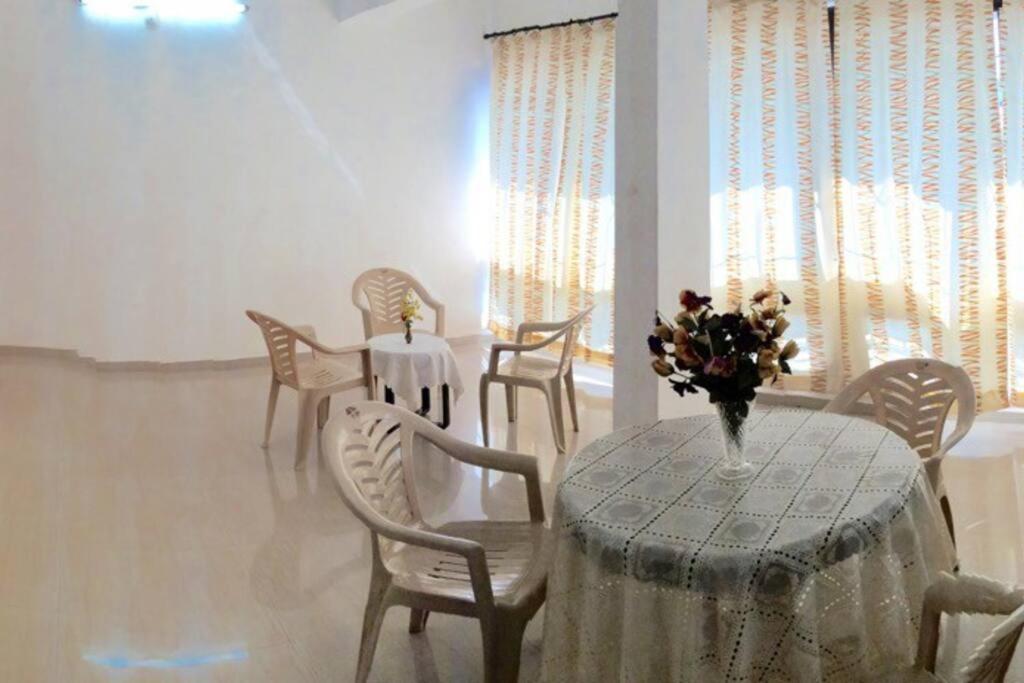Cozy Family Holiday في مادغاون: غرفة طعام مع طاولة مع إناء من الزهور عليها