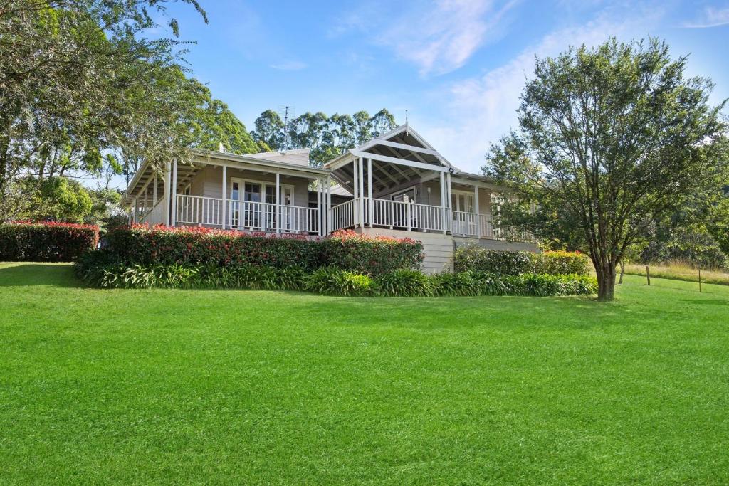 a house with a large yard with green grass at Wild Rose Cottage Kiaroo Estate, Kangaroo Valley in Kangaroo Valley