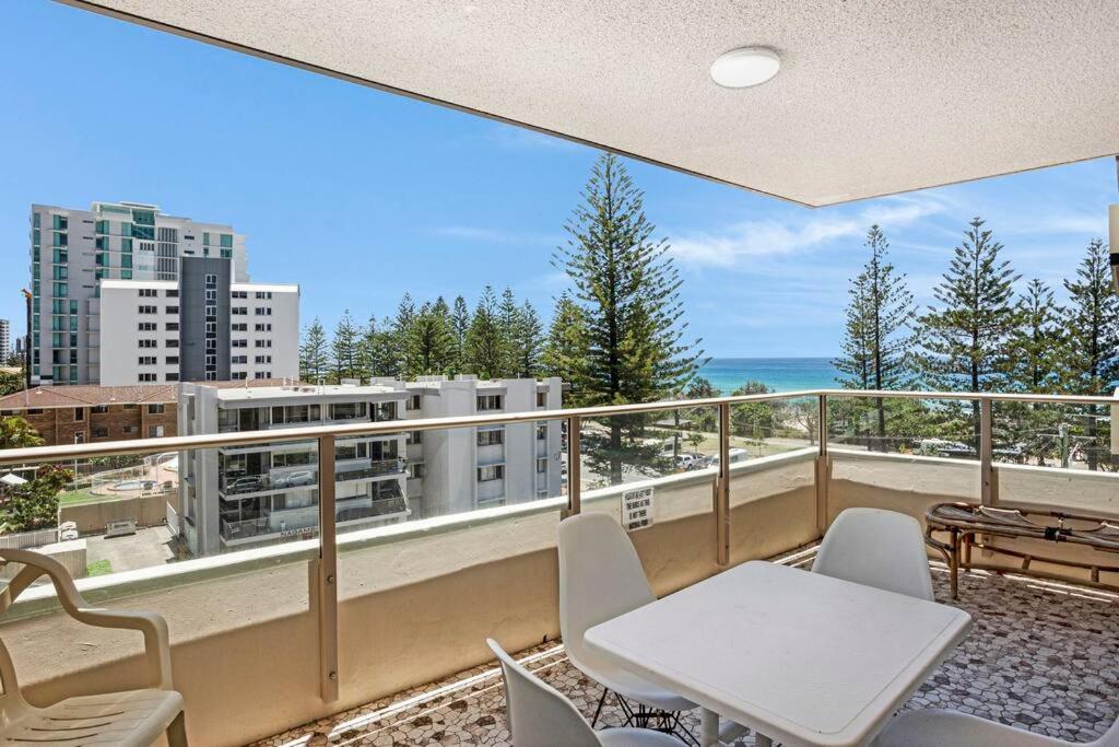 a balcony with a table and chairs and the ocean at Wyuna - Walking distance to burleigh in Gold Coast