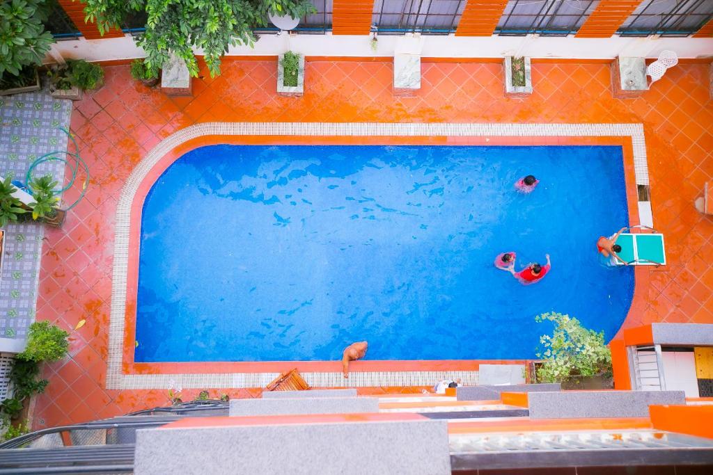 una piscina con 2 personas nadando en ella en Nana Vientiane Hotel en Vientián