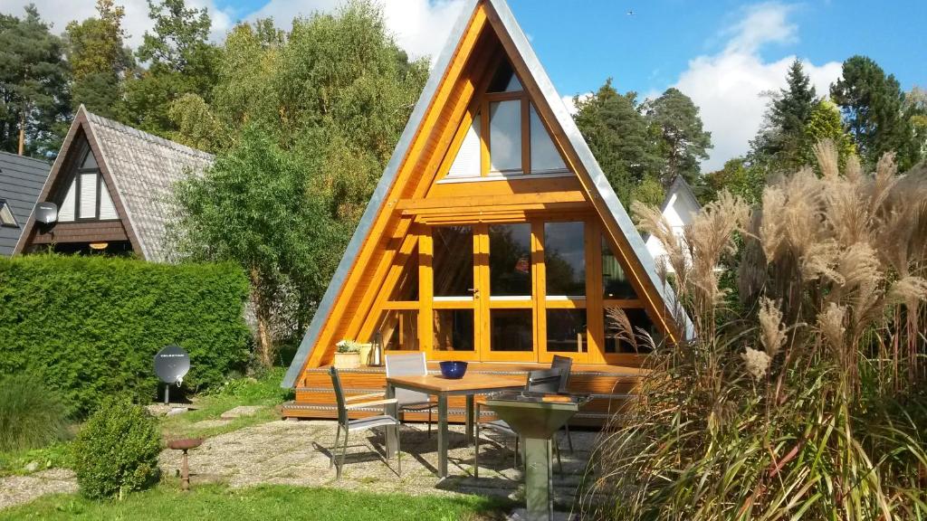 una casa marco con una mesa en un jardín en Nurdachhaus Ferienpark Schellbron, en Schellbronn