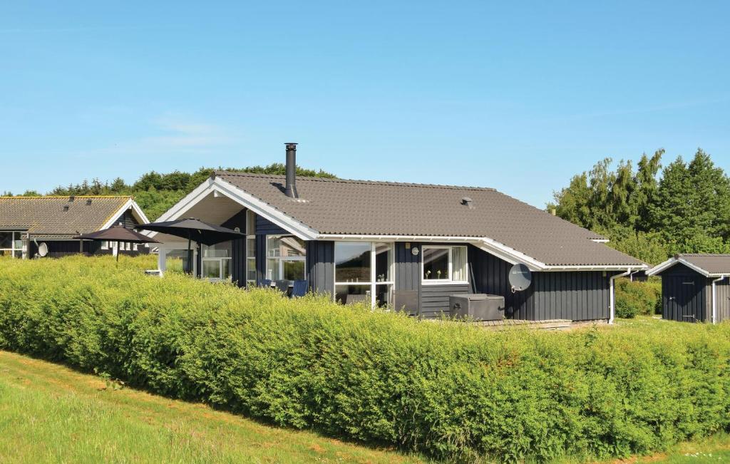 een huis op een heuvel met een groene tuin bij Stunning Home In Rudkbing With Sauna in Spodsbjerg