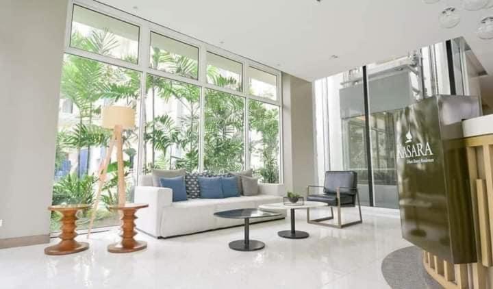 a living room with a white couch and a large window at Kasara Urban Resort 1BR Condo in Manila