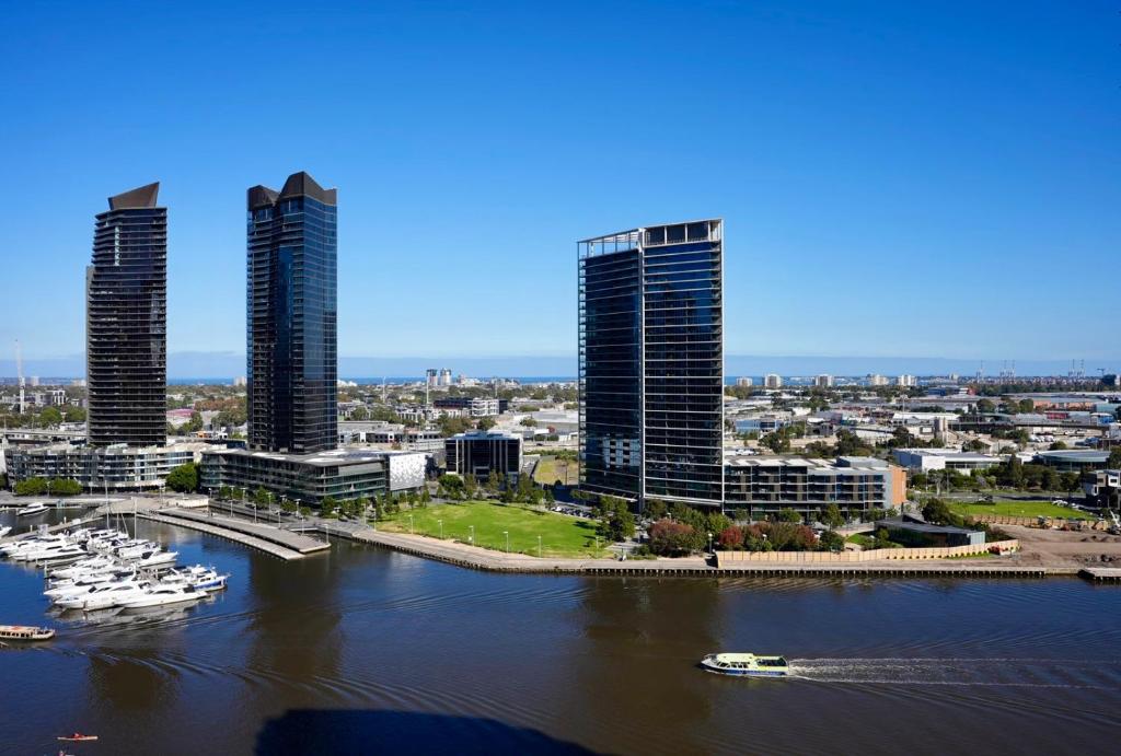a city with tall buildings and boats in the water at Infinity Lux Apartment in Melbourne