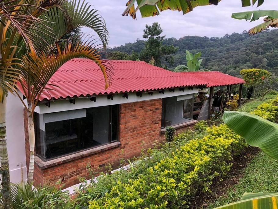 une maison en briques avec un toit rouge sur une colline dans l'établissement Villa Diana, Condominio Oasis, à Guayabal de Síquima