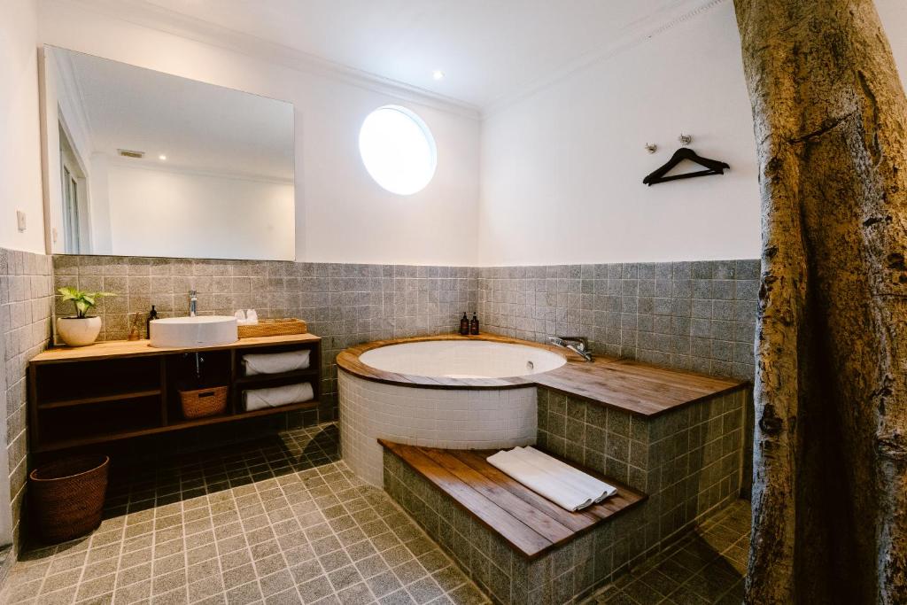 a bathroom with a tub and a sink at Brown Feather Hotel in Seminyak