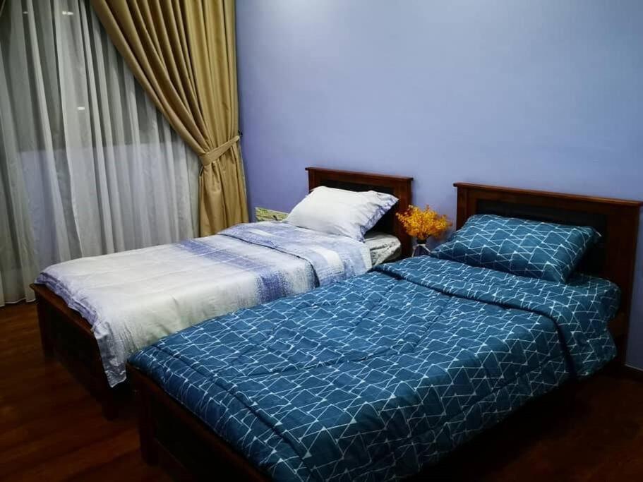 two beds sitting next to each other in a bedroom at Vivacity Megamall Jazz Suite 3BR 7pax #Joyoustayz in Kuching