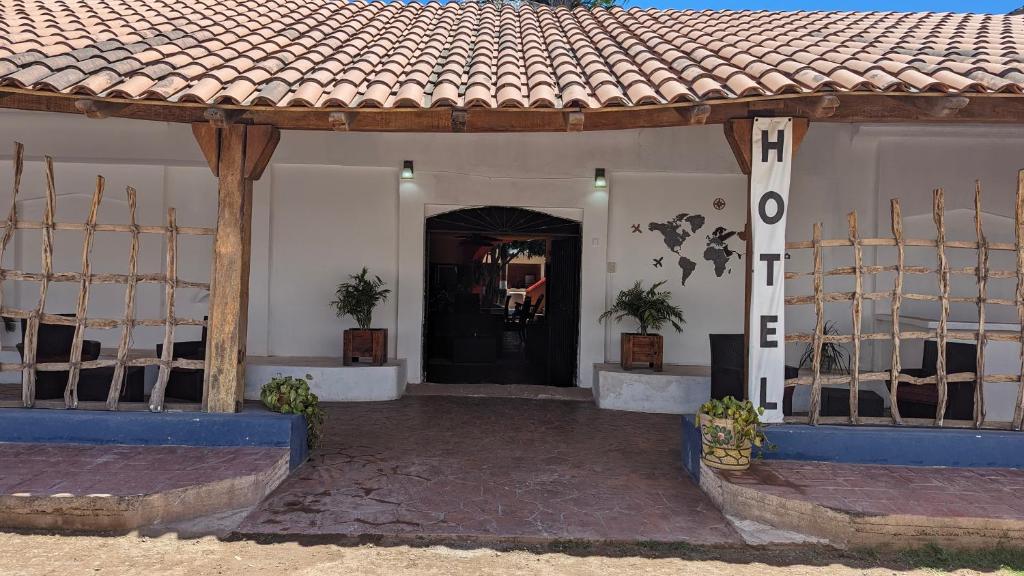 a house with a black door and a tile roof at Hostal ROCA INN in Mazatlán