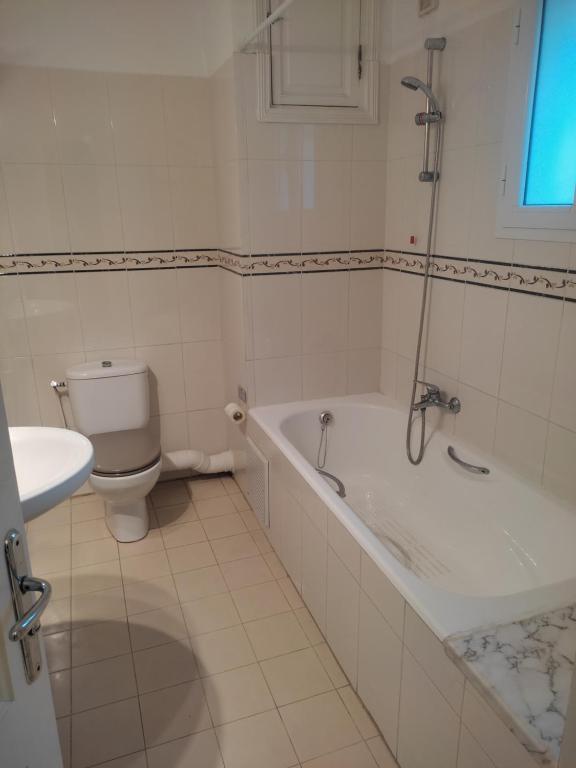 La salle de bains est pourvue d'une baignoire, de toilettes et d'un lavabo. dans l'établissement Appart Cozy, à Le Bardo