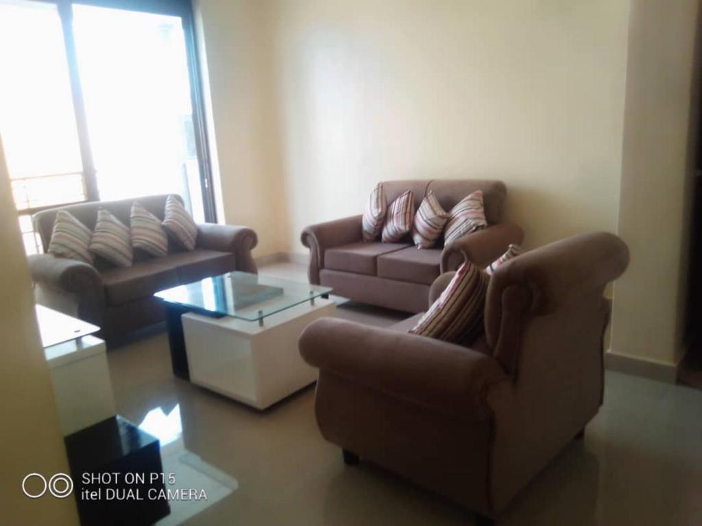 a living room with two couches and a coffee table at VILLA FIORI APARTMENTS in Arua