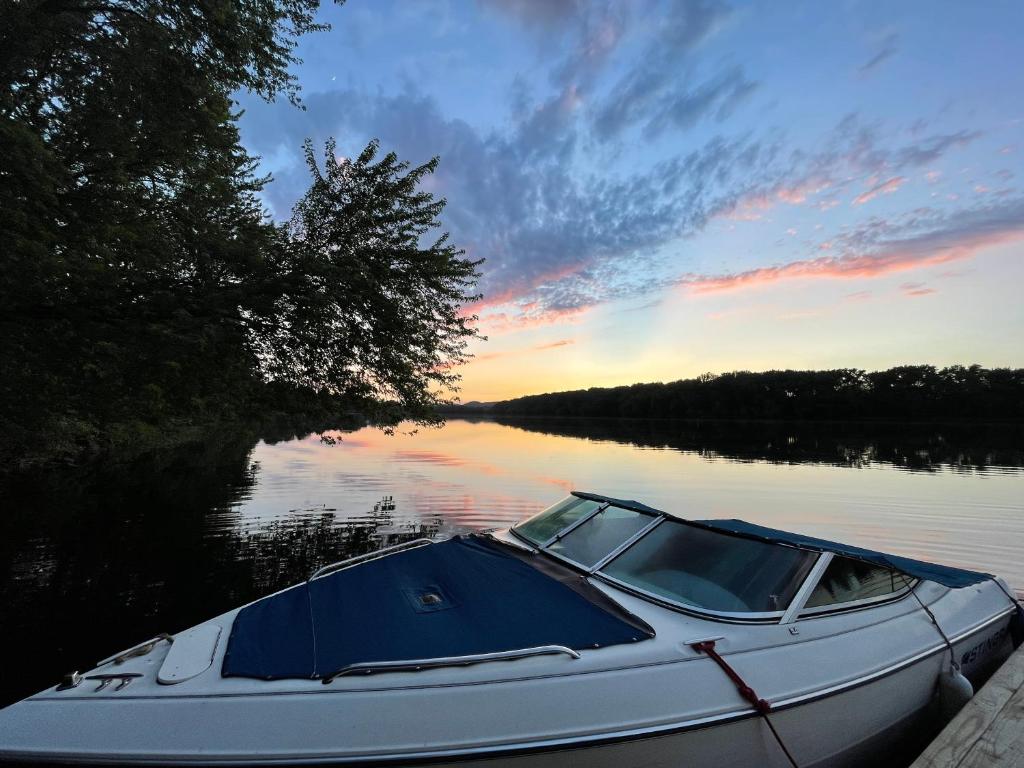 una barca è ormeggiata su un lago al tramonto di River House a South Williamsport