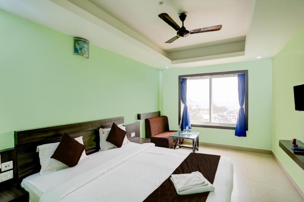 Schlafzimmer mit einem großen Bett und einem Deckenventilator in der Unterkunft Hotel Deep Ganga Inn Puri Sea View Room in Puri
