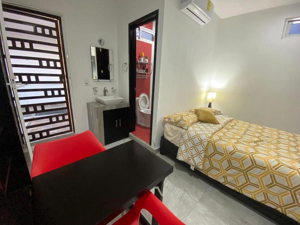 a bedroom with a bed and a table and a chair at Un departamento a tu gusto in Valladolid