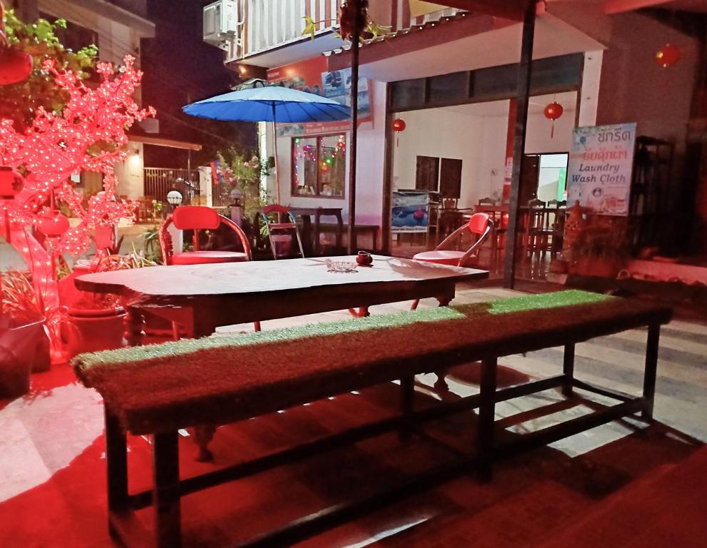 a ping pong table and a bench in a room at Queens Backpackers in Vang Vieng