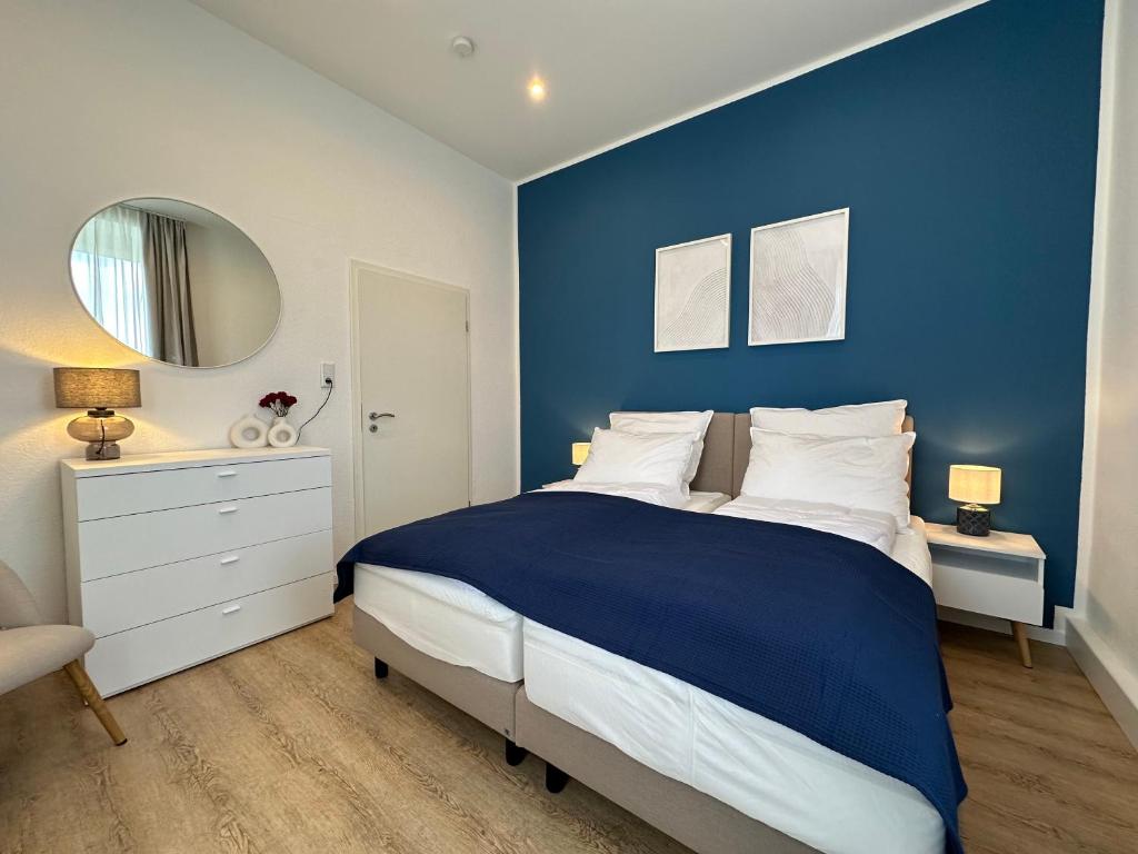 a blue bedroom with a bed and a mirror at SHINY HOMES - Bielefeld Mitte in Bielefeld