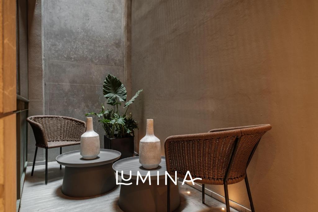 a table with two vases and two chairs at Casa Cibeles by Lumina in Mexico City