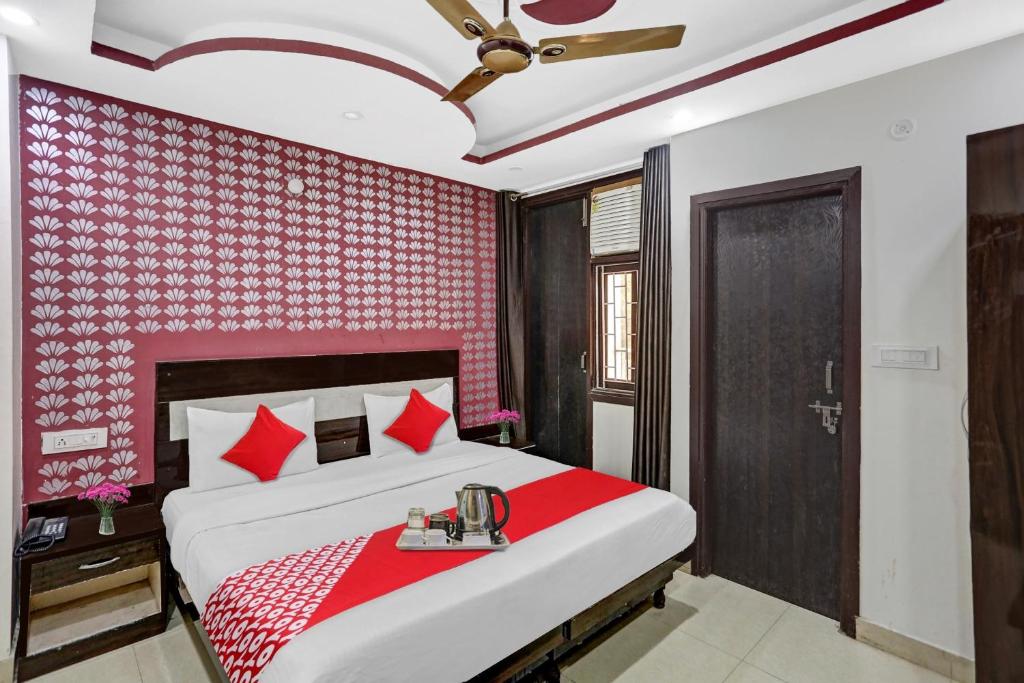Schlafzimmer mit einem Bett mit einer rot gemusterten Wand in der Unterkunft OYO Flagship Hotel Blue Orchid in Neu-Delhi