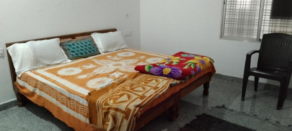 Cama en habitación con silla y cama sidx sidx en happy khajuraho home stay en Khajurāho