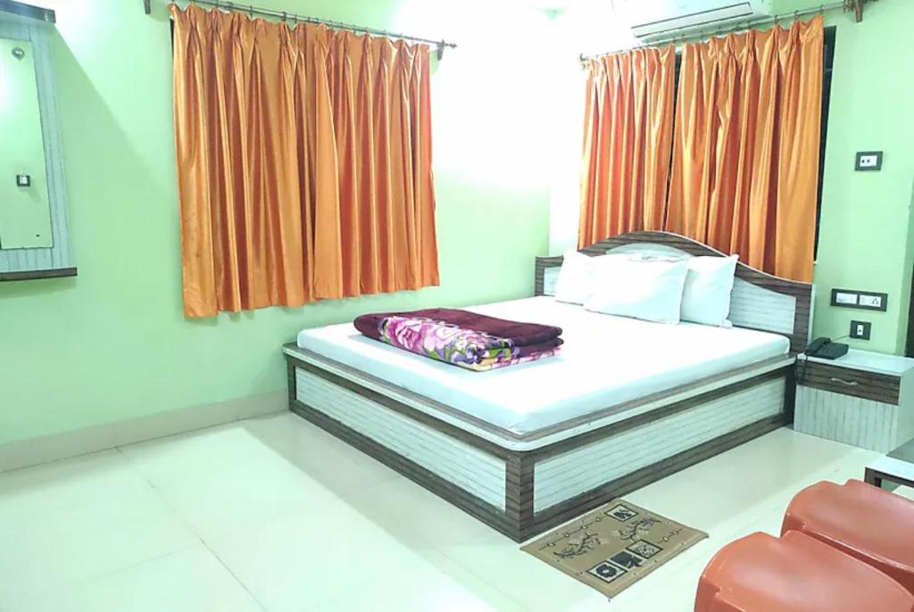 um quarto com uma cama, uma janela e uma cadeira em Goroomgo Muskan Guest House Digha em Digha