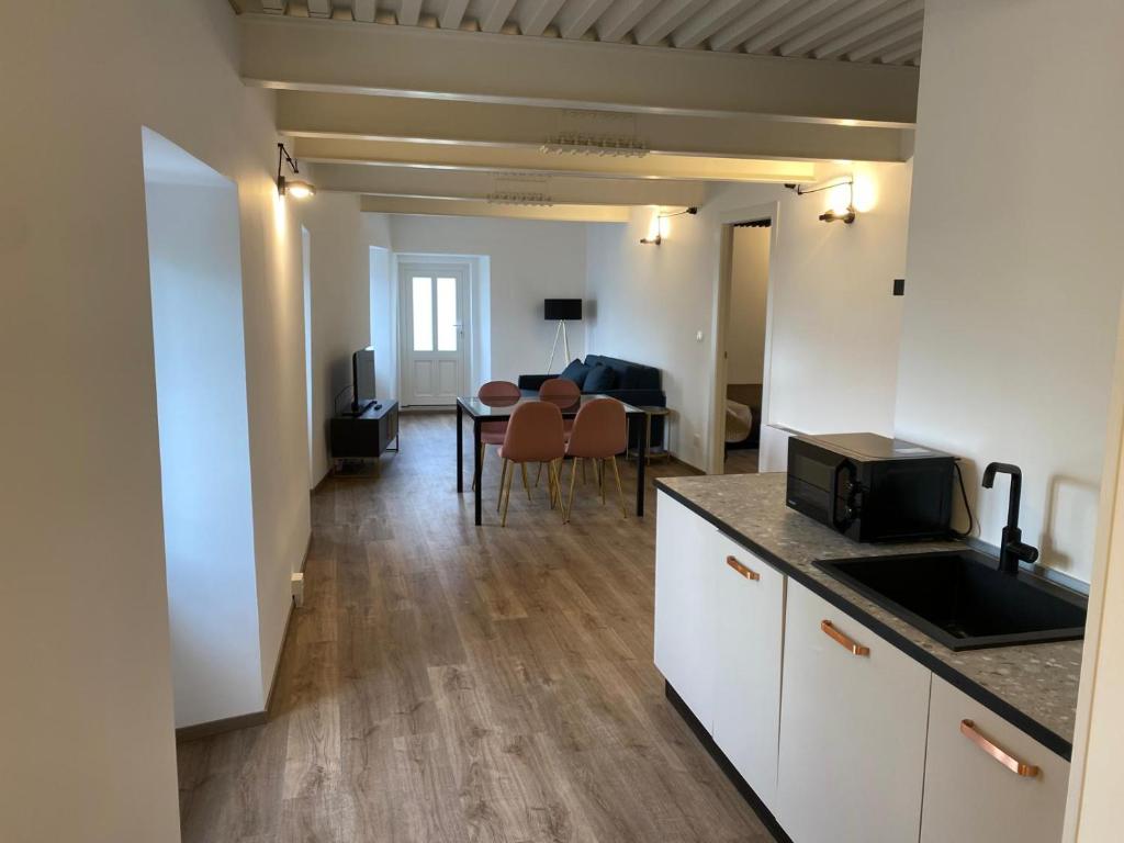 een keuken en een woonkamer met een tafel bij Al FRONTE MARE SUITES APARTMENTS in Muggia