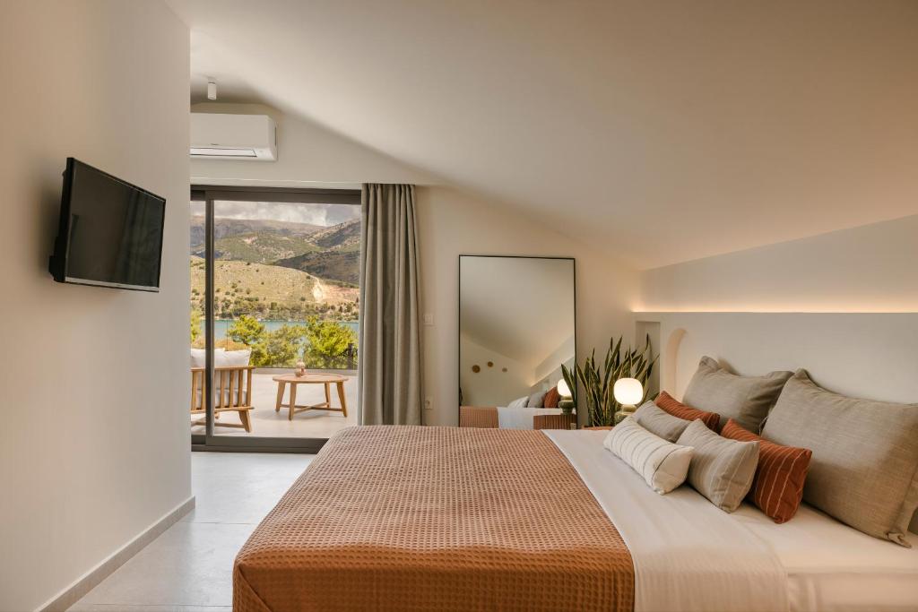 sypialnia z dużym łóżkiem i telewizorem na ścianie w obiekcie Veranda Suite w mieście Argostoli