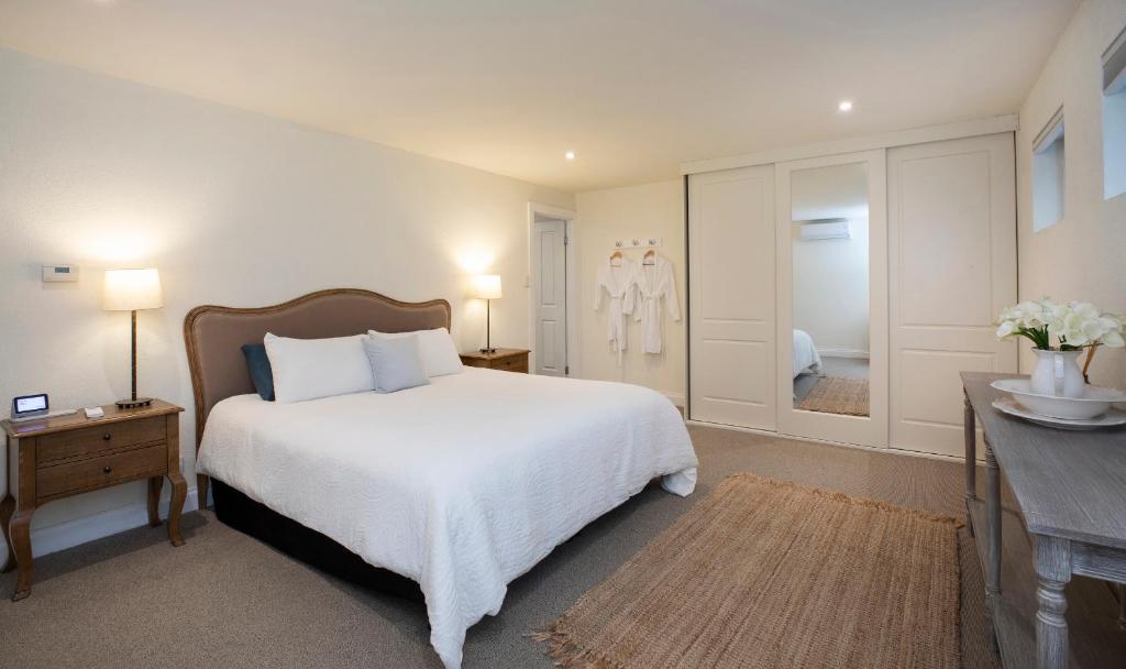 a bedroom with a white bed and a walk in shower at The Retreat at Stirling in Stirling