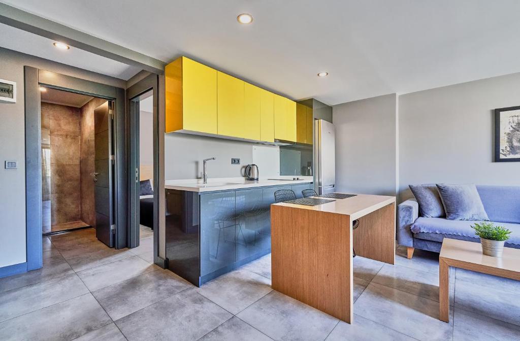 a kitchen with yellow cabinets and a blue couch at Loft 1502 in Antalya