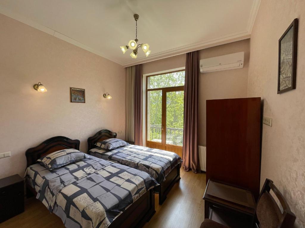 1 Schlafzimmer mit 2 Betten und einem Fenster in der Unterkunft Freedom Square Apartment in Tbilisi City
