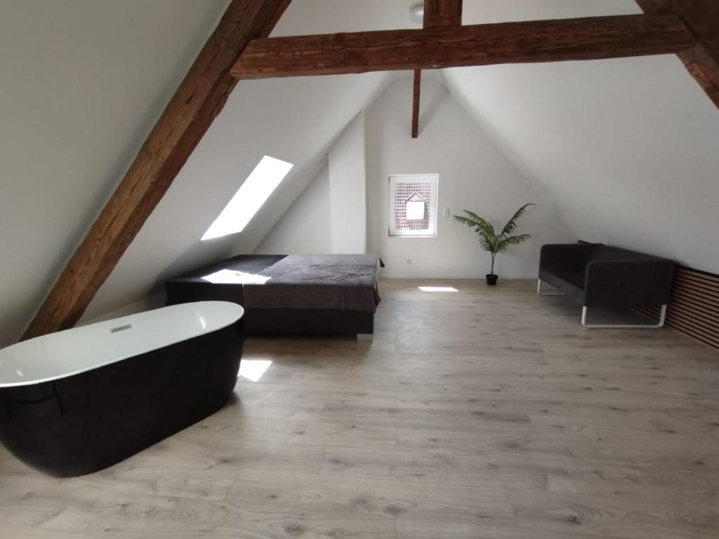 a attic room with a bath tub and a bed at Loft Apartment am Bahnhof in Albstadt