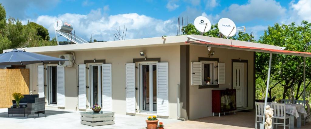 een klein huis met een dak en een paraplu bij Philip estate in Ágios Nikólaos