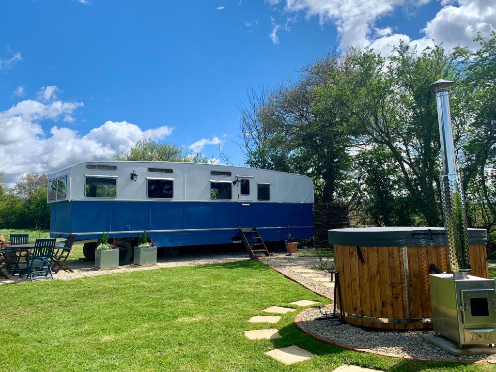 niebiesko-biała przyczepa zaparkowana na dziedzińcu w obiekcie The Showman, Luxury Camper w mieście Halford