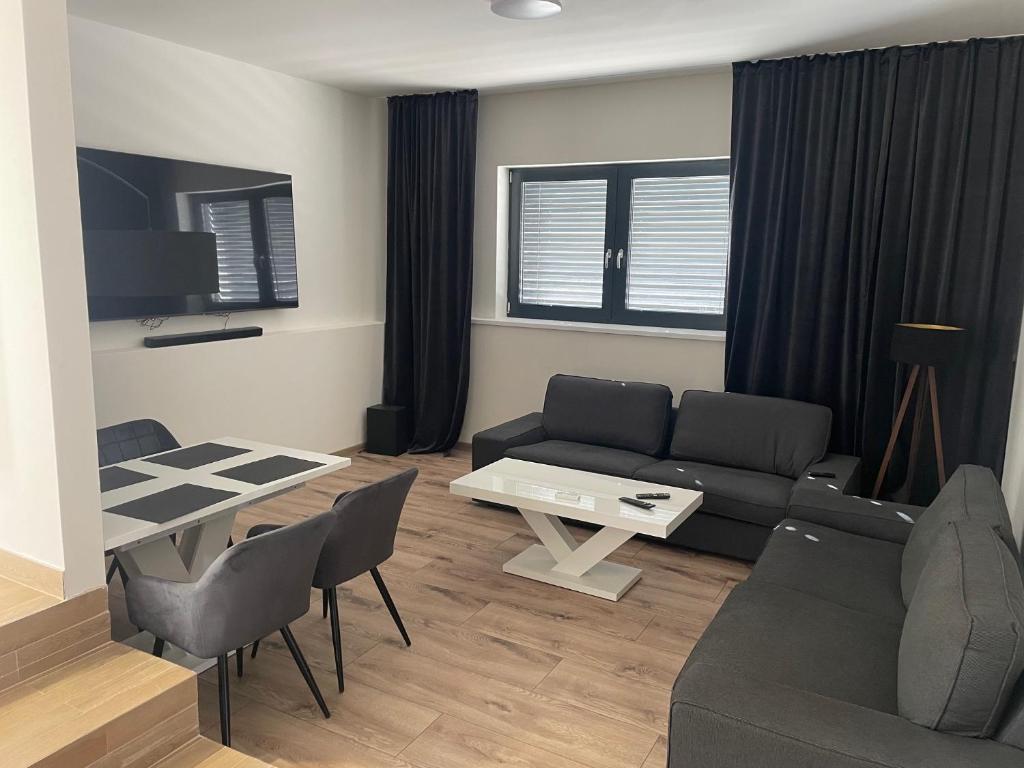 ein Wohnzimmer mit einem Sofa und einem Tisch in der Unterkunft City Apartment - Michalovce in Michalovce