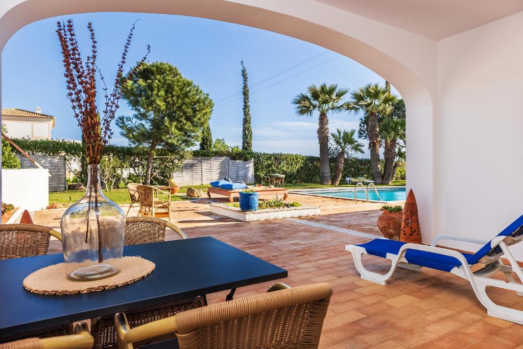 a patio with a table and chairs and a pool at Quinta Terruta by Ocvillas in Albufeira