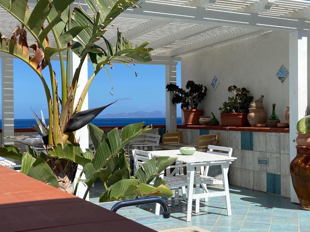 a patio with a table and chairs and a view of the ocean at Rosa Dei Venti Marettimo in Marettimo