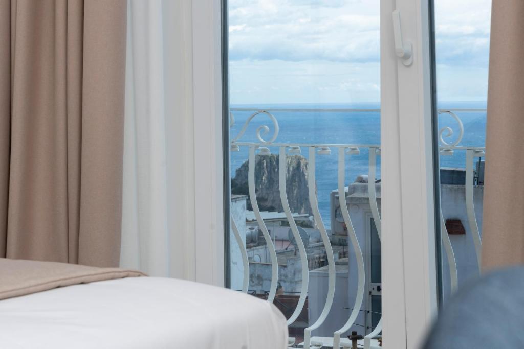 a room with a balcony with a view of the ocean at Sopramonte 7 in Capri