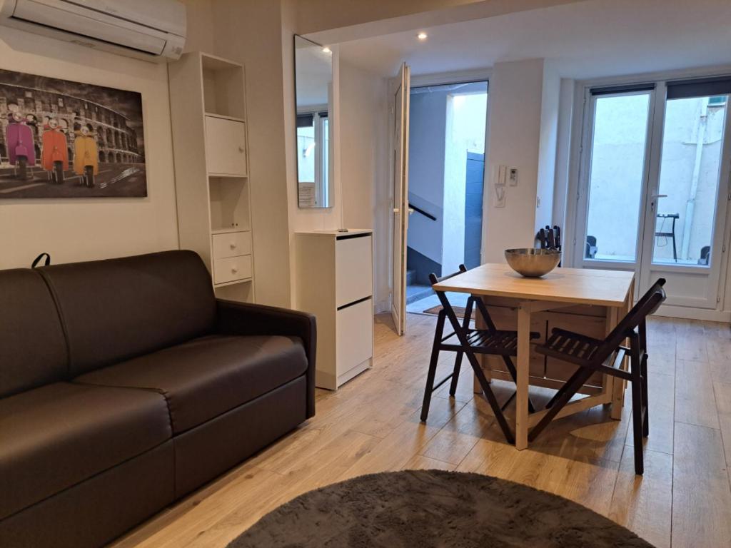 a living room with a couch and a table at Studio avec Terrasse à 5 minutes de la plage in Saint-Laurent-du-Var