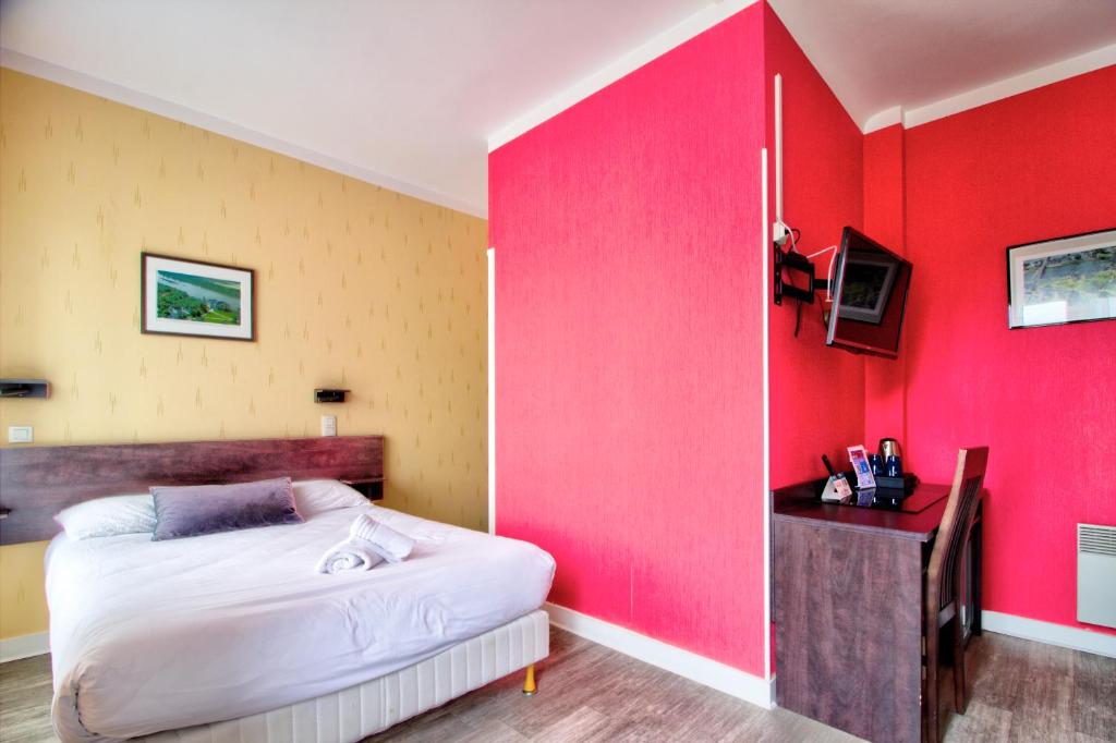 a bedroom with a red wall and a bed at Logis Hôtel Des Châteaux De La Loire in Tours