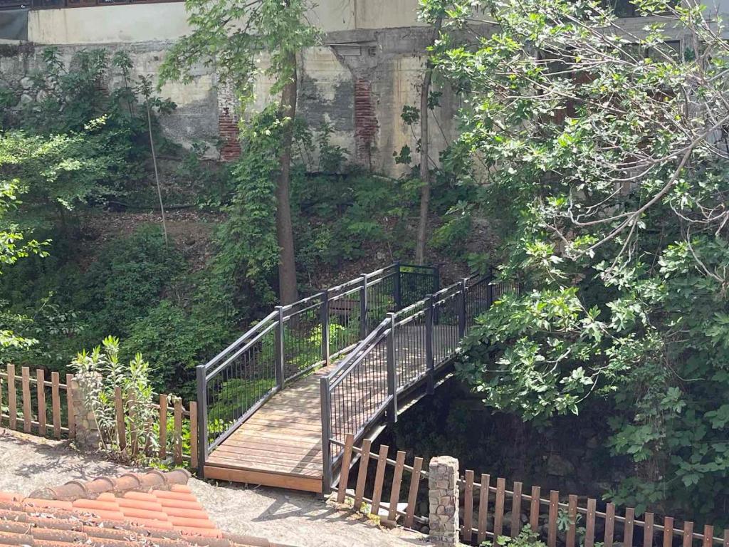 uma passagem de madeira que leva a uma ponte num jardim em Galata's Bridge Boutique Hotel em Galata