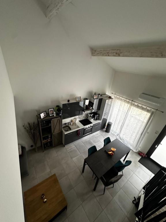 uma sala de estar com uma mesa e uma cozinha em APPARTEMENT PLEIN CENTRE em Bernis