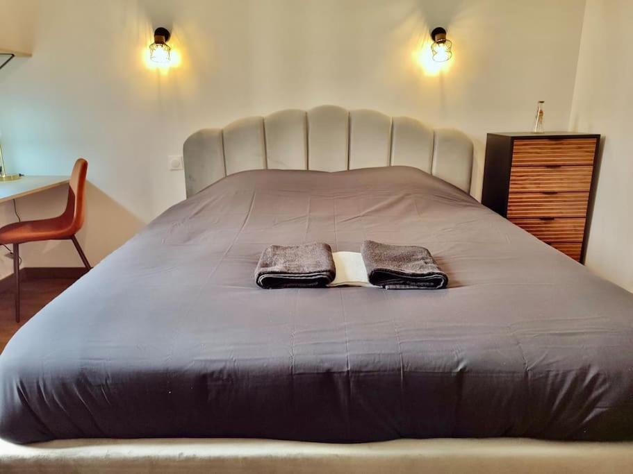 uma cama grande com duas toalhas em cima em L'Ambre - Appartement Raffiné em Perpignan