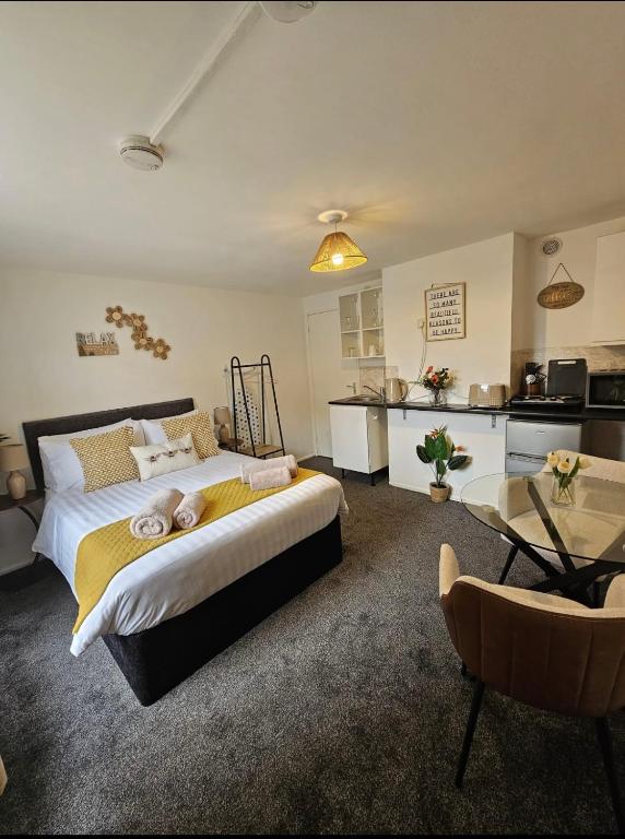 a bedroom with a large bed and a kitchen at Studio in Stevenage