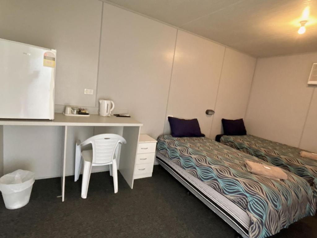 Camera piccola con letto, scrivania e sedia. di Lyndhurst hotel SA 